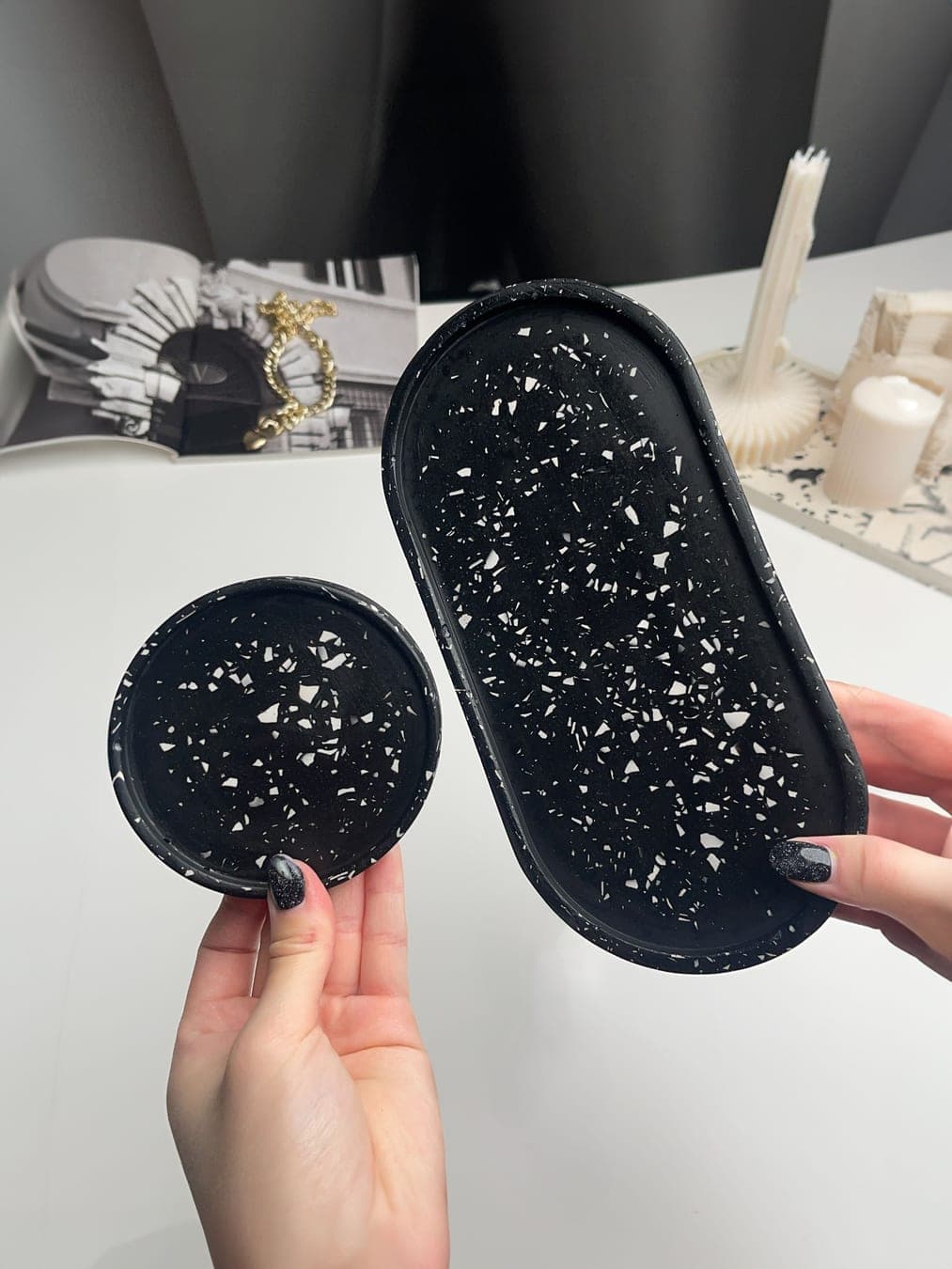 Black terrazzo tray and coaster held in hands